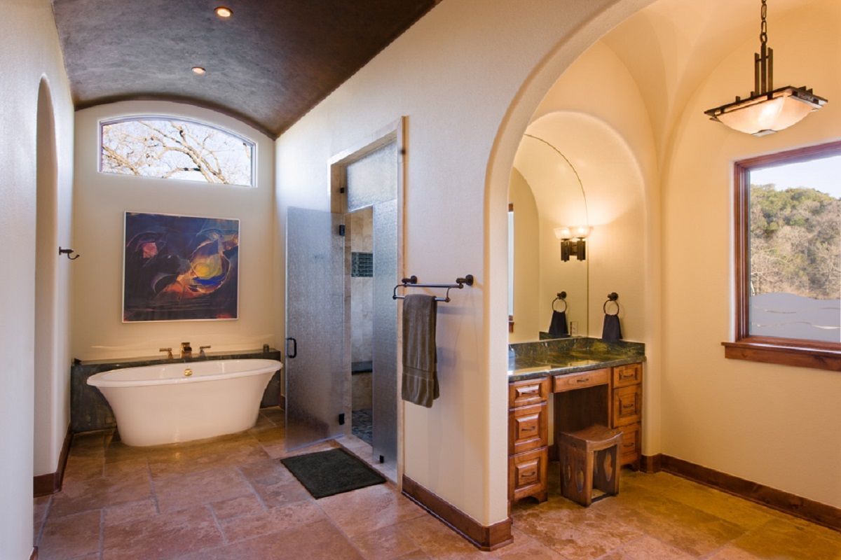 Elegant bathroom with a standalone tub, glass shower, and vanity area.