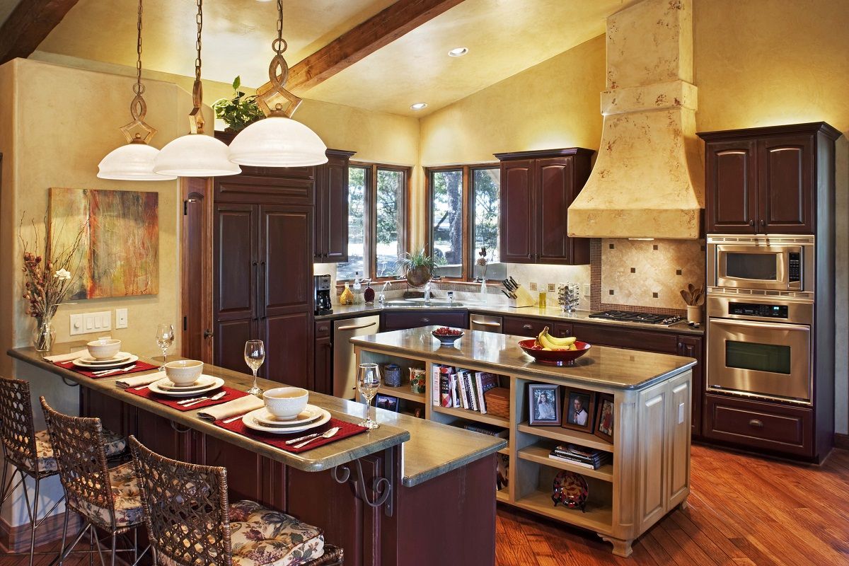 Cozy kitchen with dark cabinetry, island with storage, and a breakfast bar, with warm lighting and wooden floors.
