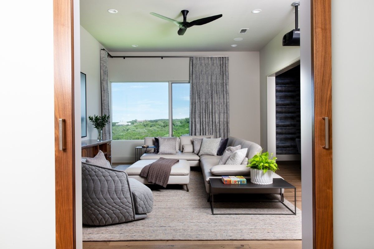 Living room with sectional sofa, curtains, rug, and large window overlooking a landscape.