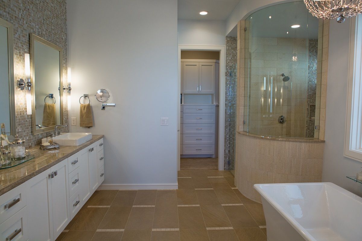 Elegant bathroom with white cabinets, a glass shower, and a standalone tub.