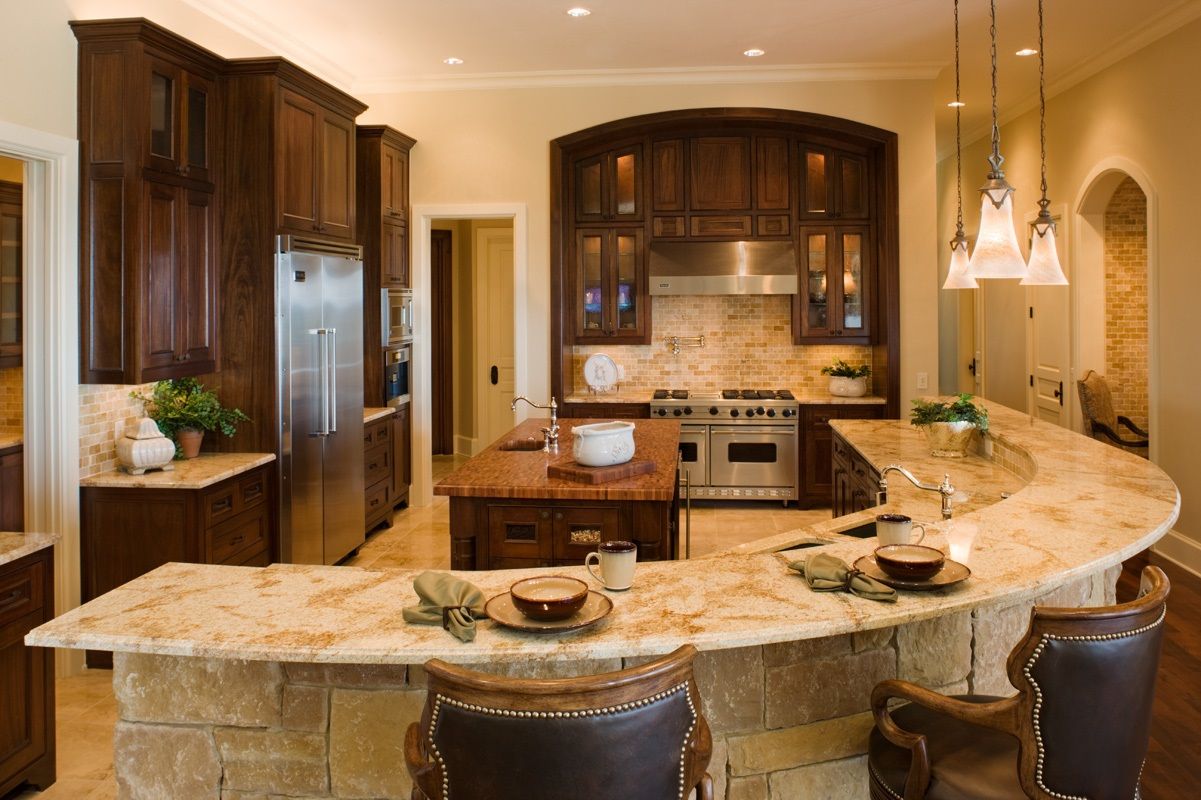 Upscale kitchen with wood cabinets, granite countertops, stainless steel appliances, and an island with bar seating.
