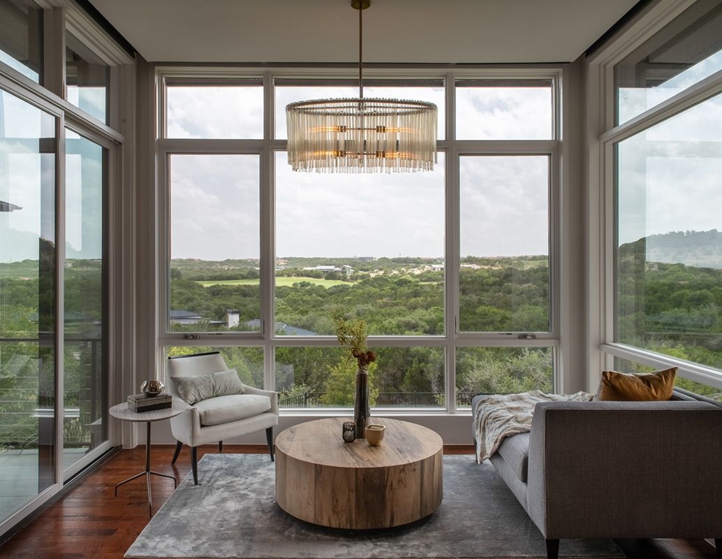Living room with large windows overlooking a green landscape