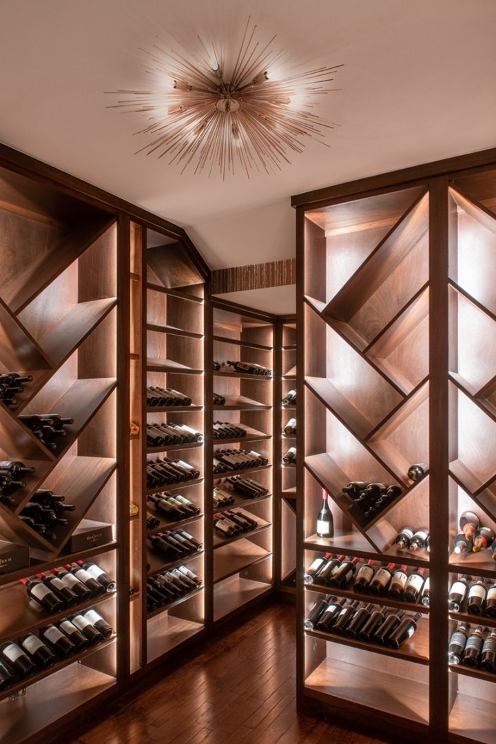 Wine cellar with wooden shelves, bottles, and a starburst light fixture.