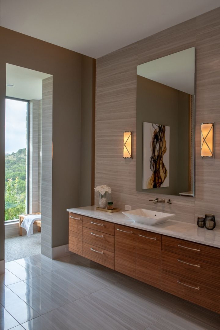Modern bathroom with floating wood vanity, marble countertop, and large mirror.