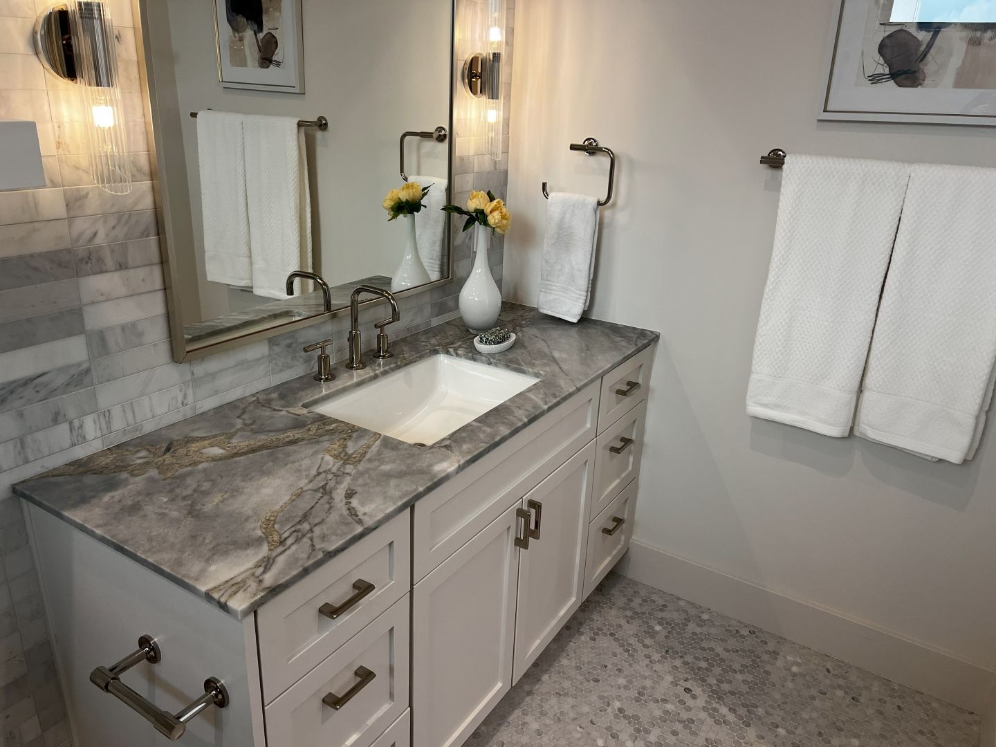 Bathroom with white vanity, gray countertop, sink, mirror, and towels.