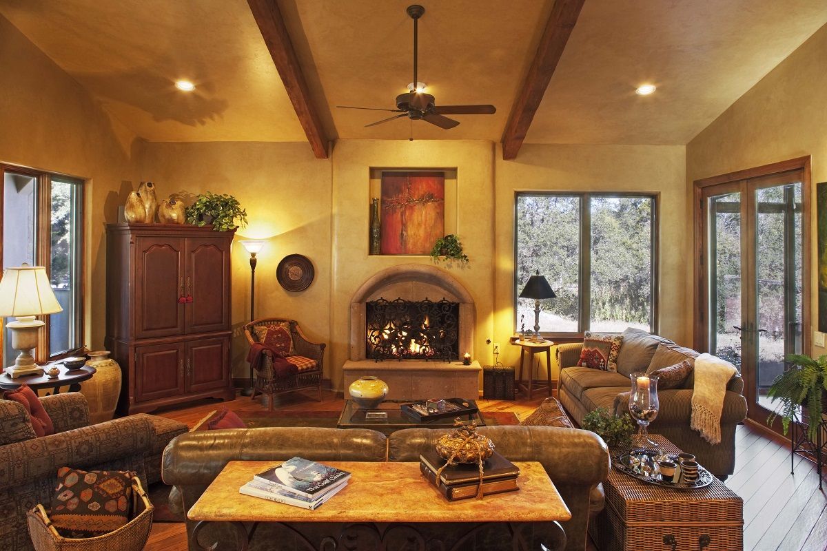 Cozy living room with a fireplace, couches, and wooden beams.