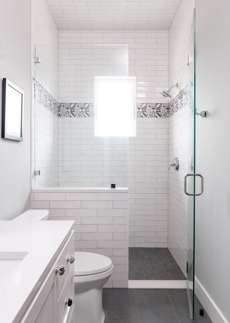 Modern white bathroom with a glass shower and gray tile floor.