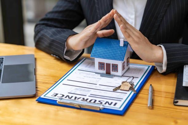A local home insurance agent assisting home buyers with their insurance needs in a friendly office.