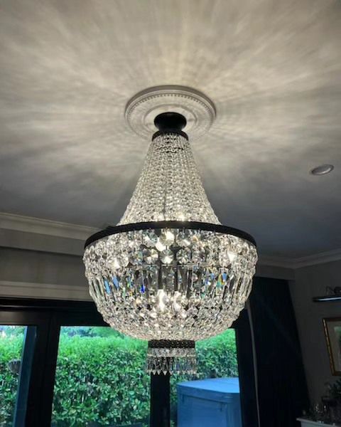 A Large Chandelier is Hanging From the Ceiling in a Living Room — Professional Electrical & Data Pty Ltd in Bonner, ACT