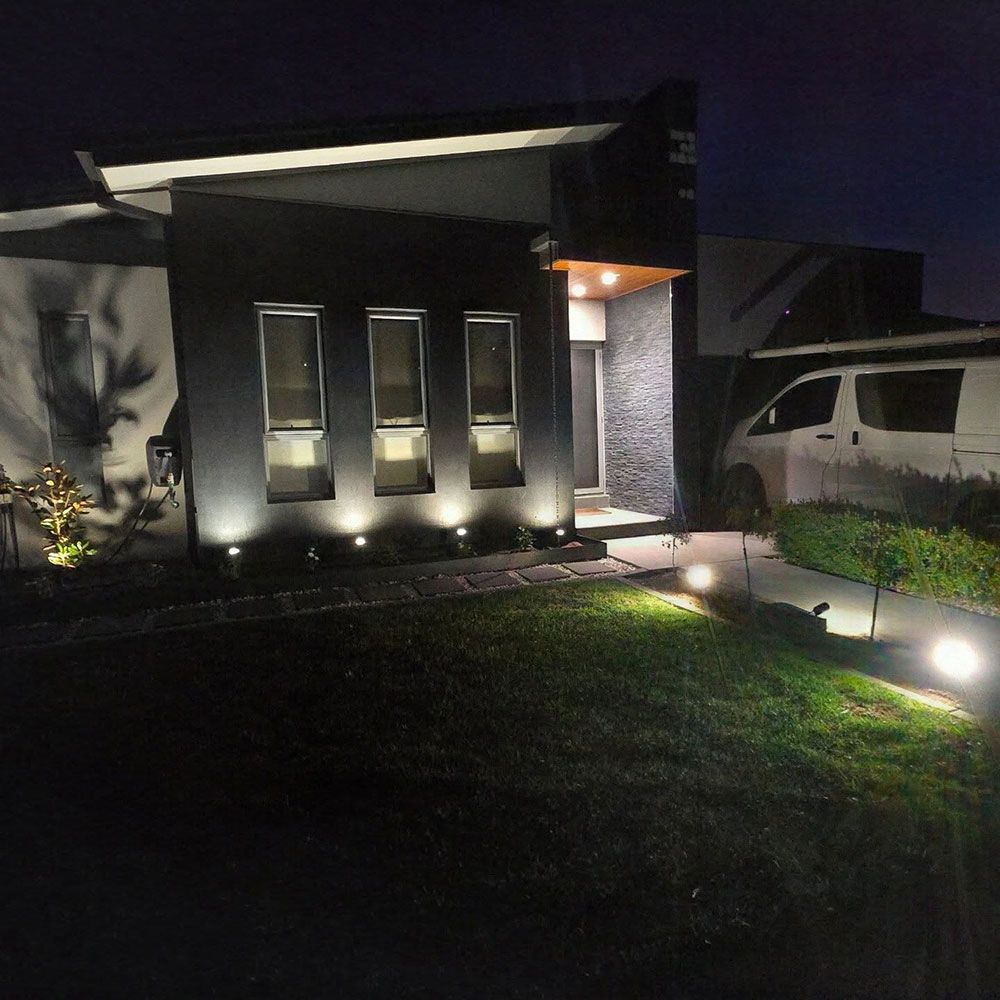 A House With a Car Parked in Front of It at Night — Professional Electrical & Data Pty Ltd in Bonner, ACT