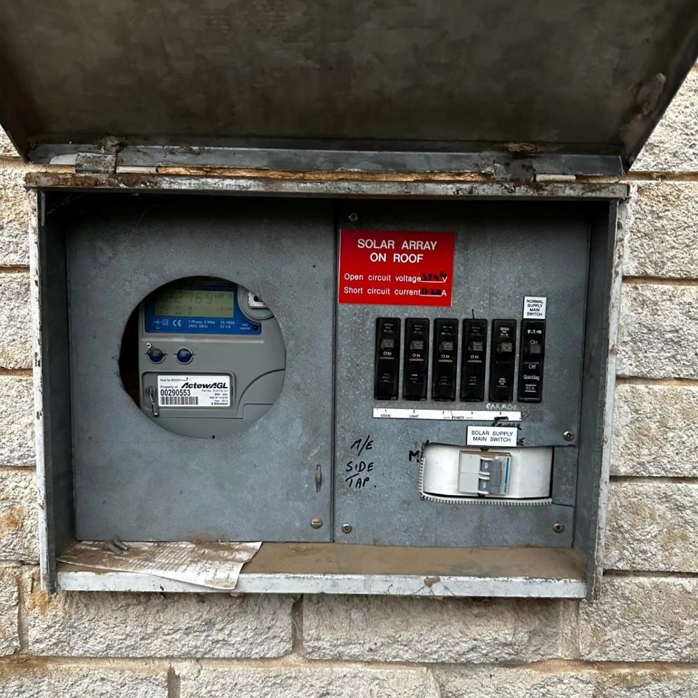 A Brick Wall Has a Box With a Meter on It — Professional Electrical & Data Pty Ltd in Bonner, ACT