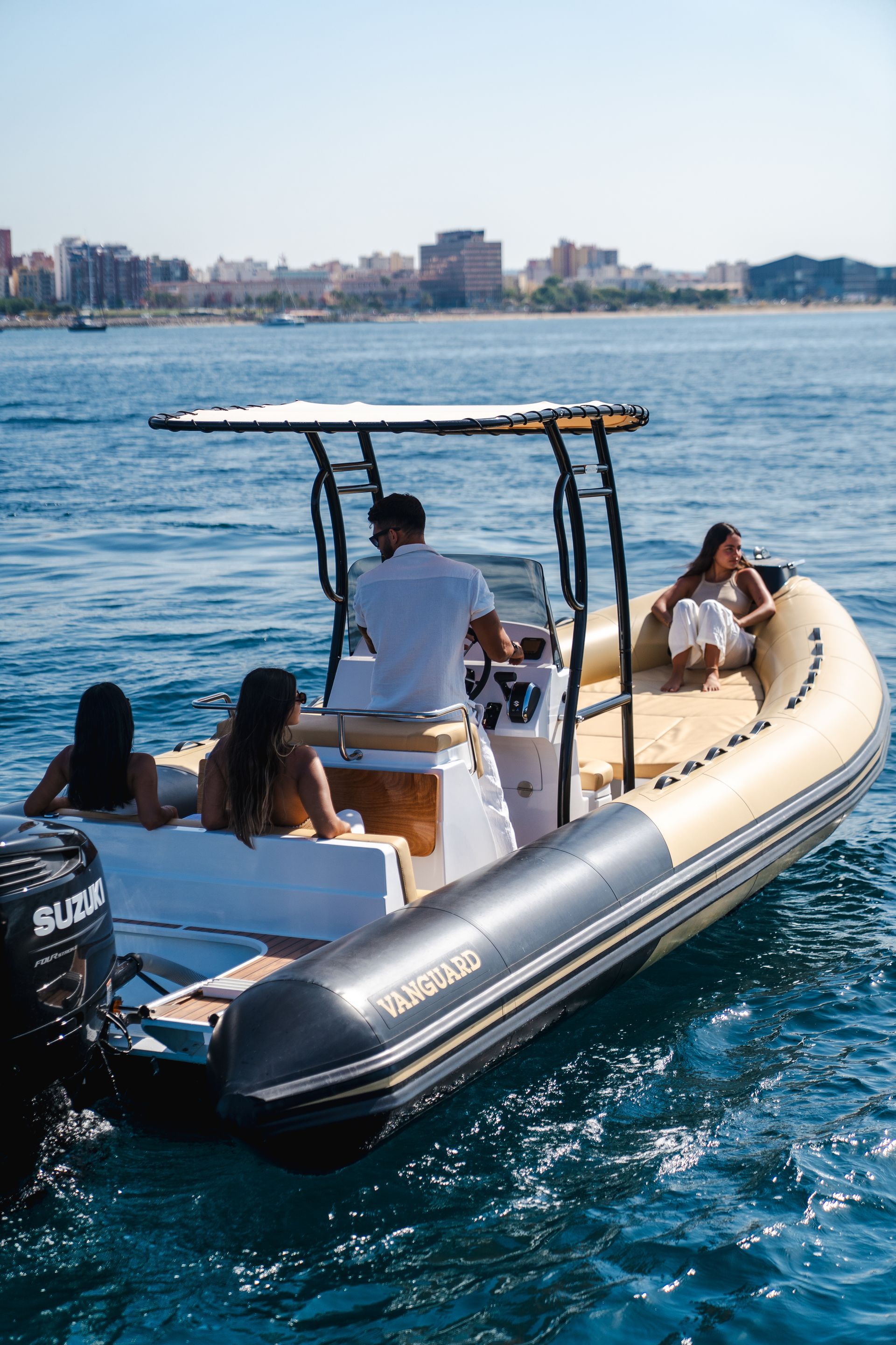 Un barco inflable motorizado con gente a bordo, navegando en un día soleado.