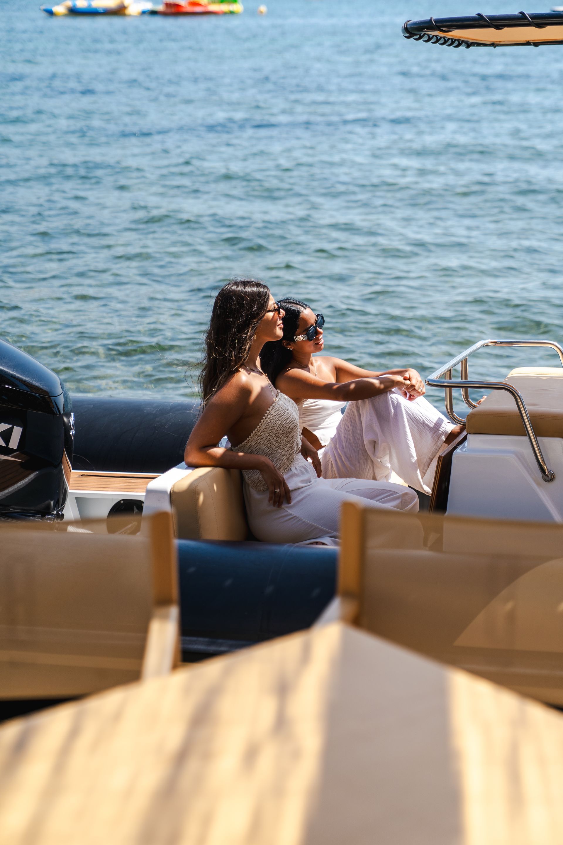 Dos mujeres en un barco, disfrutando del sol en el agua.
