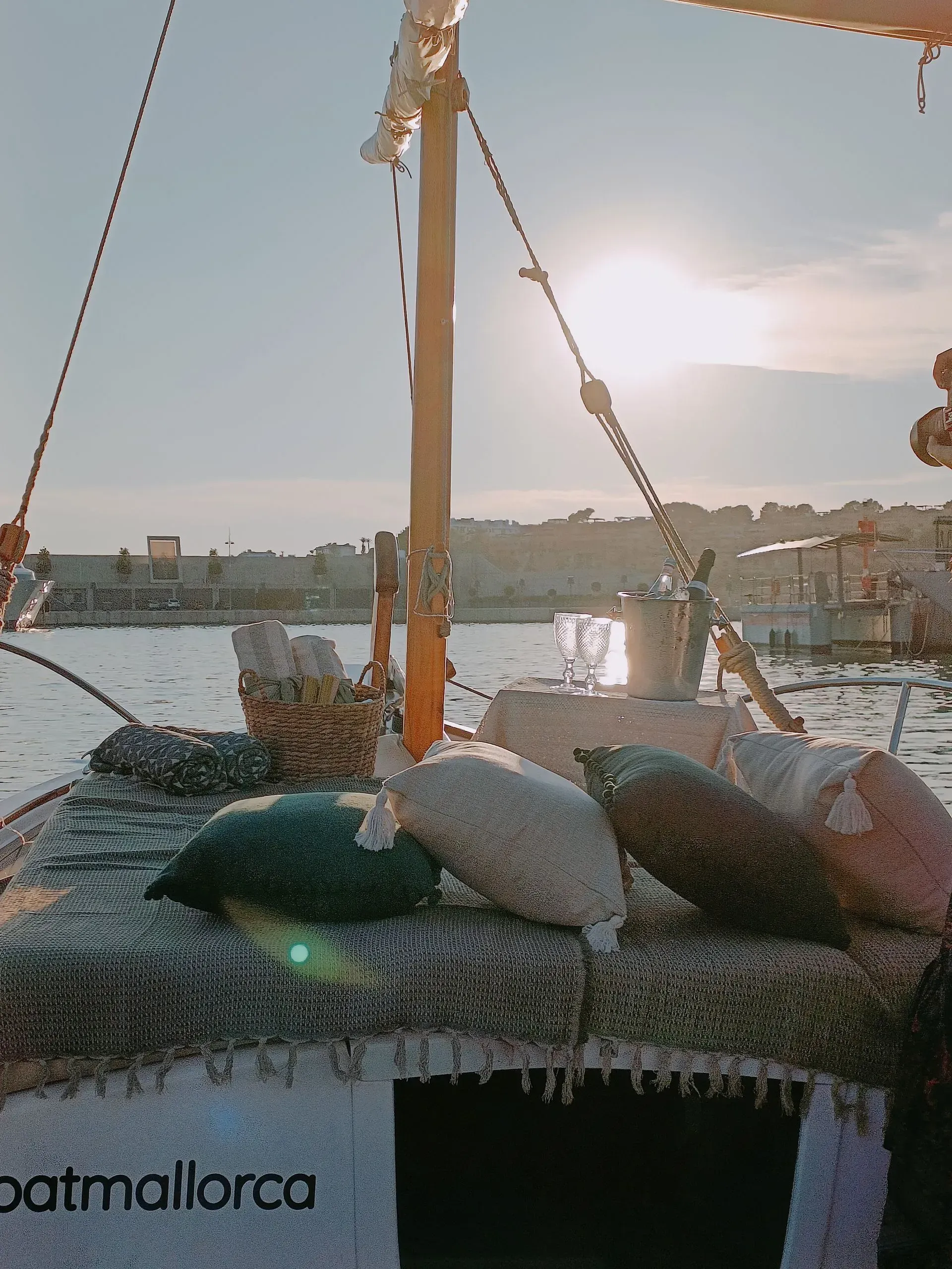 Barco pesquero al atardecer, con el puerto de fondo. 