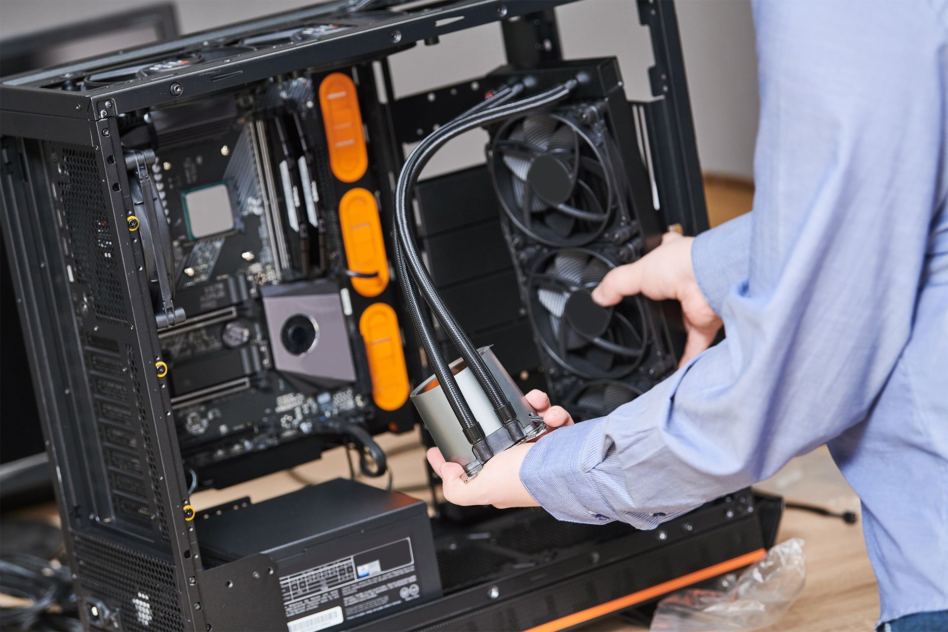 A man is installing a water cooling system on a computer