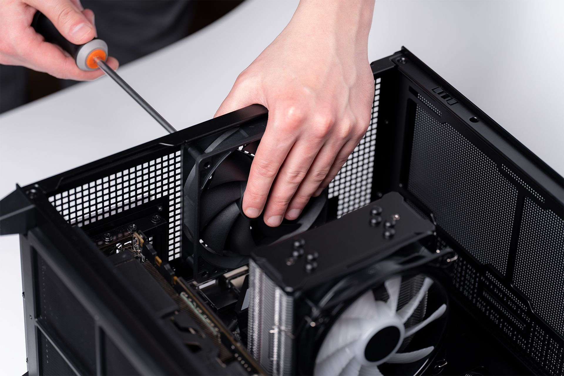 A person is fixing a computer with a screwdriver