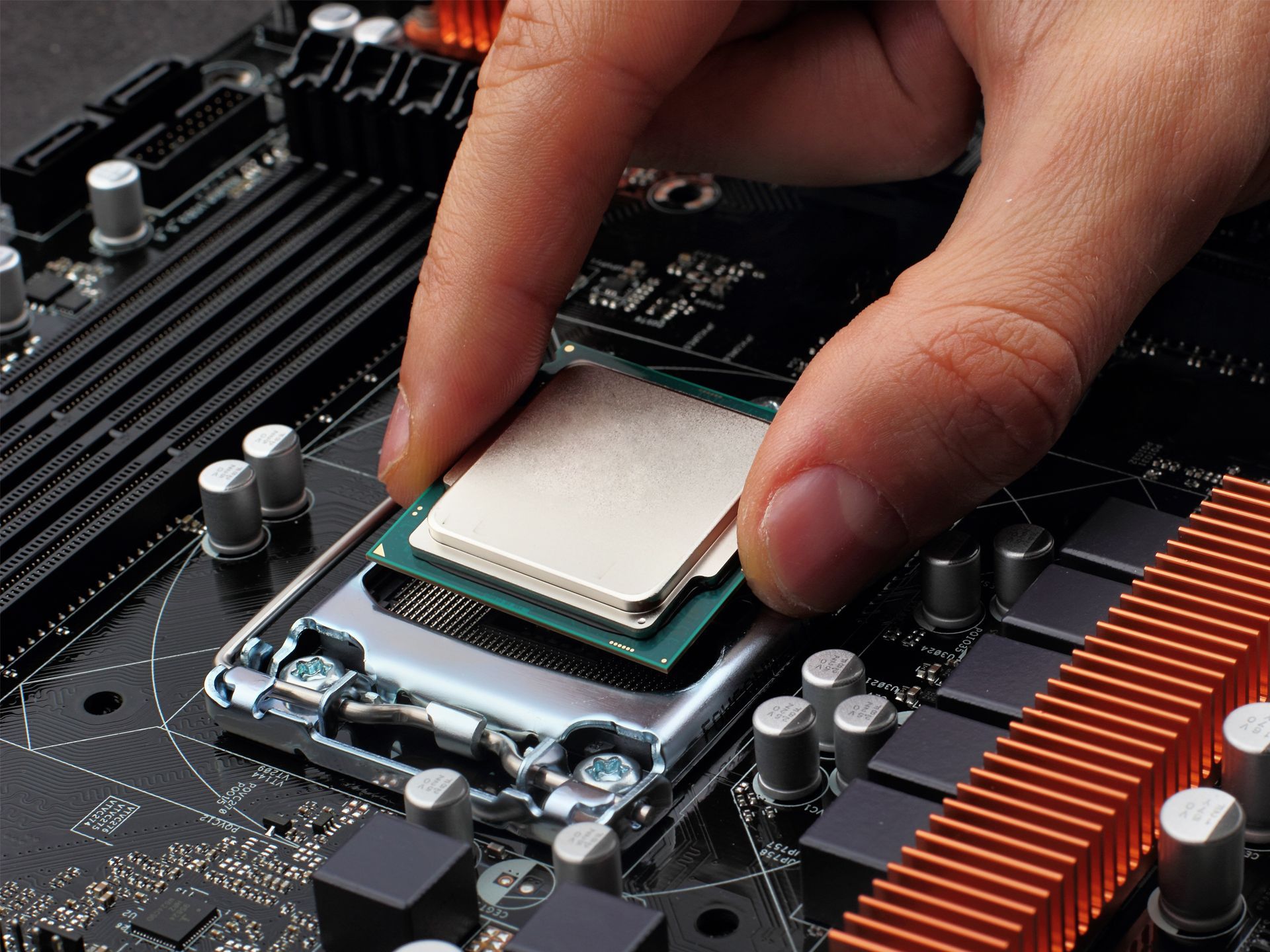 A person is installing a processor on a motherboard