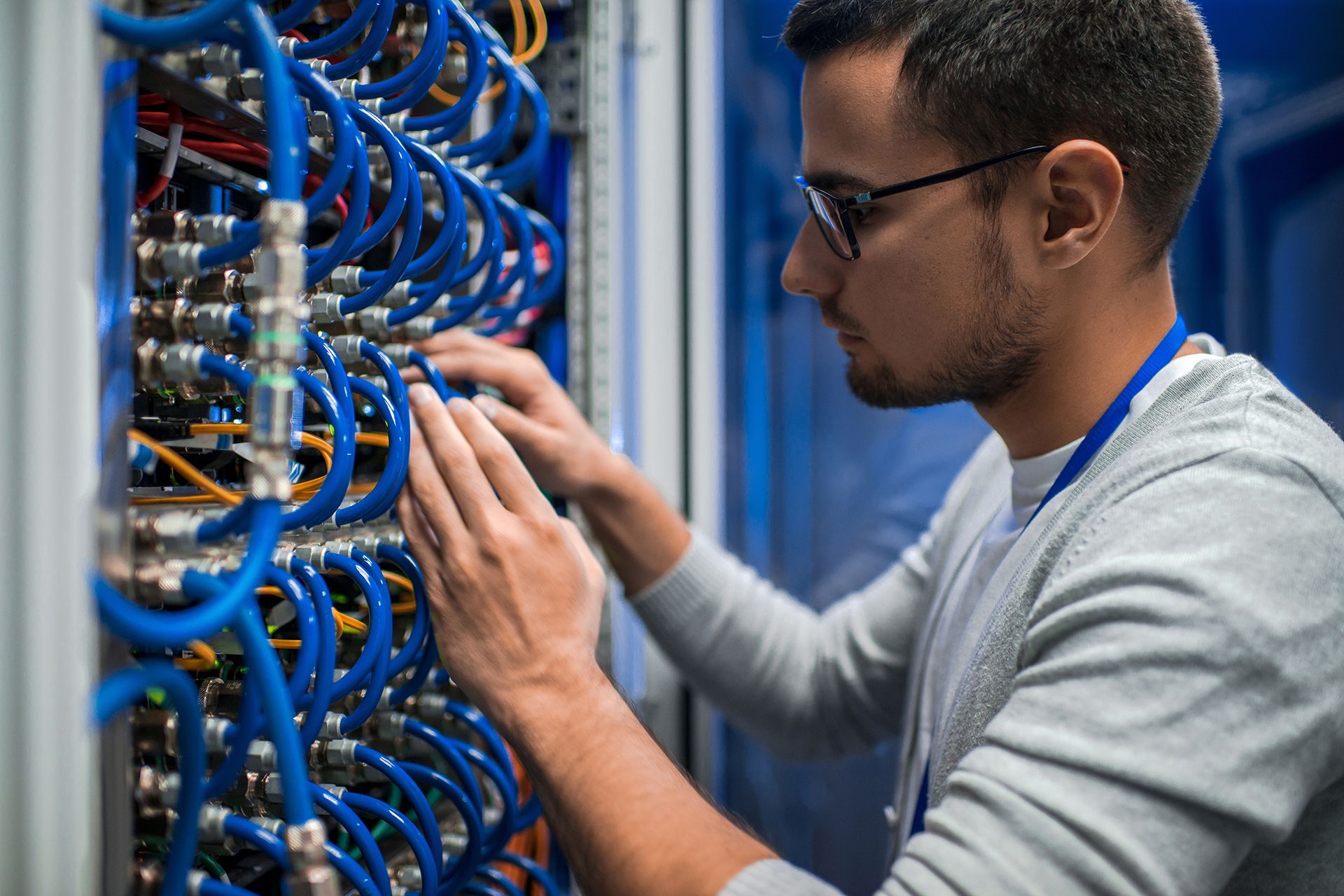 A man is working on a server in a data center