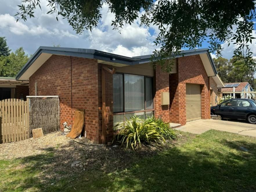 A Brick House with A Car Parked in Front of It — CBR Maintenance In Curtin, ATC