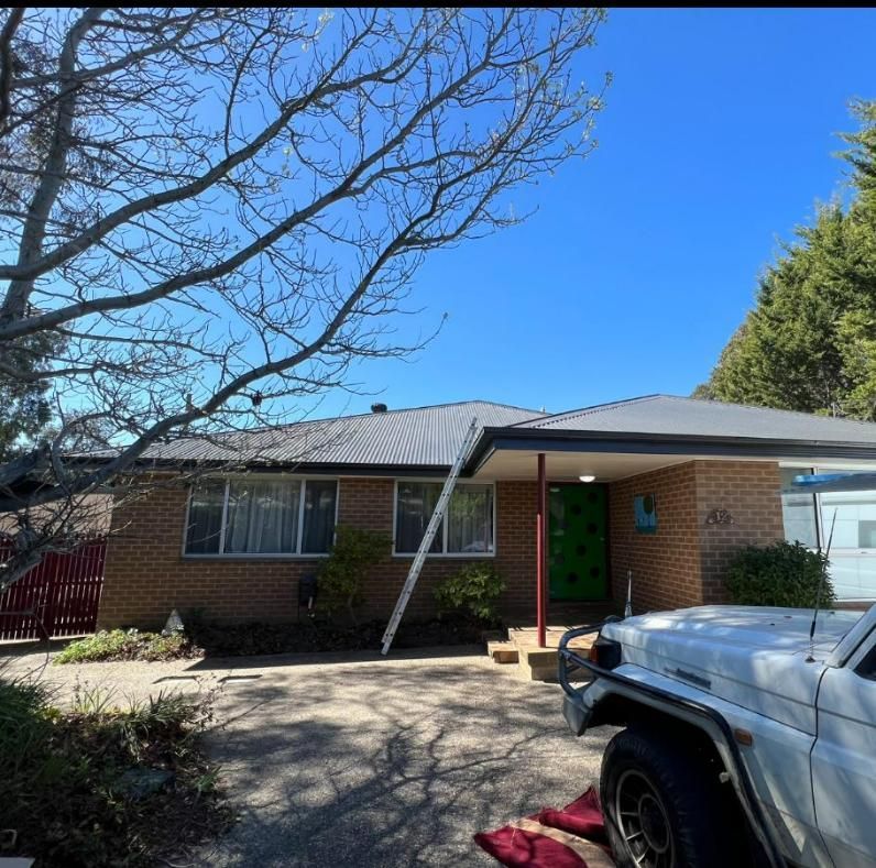 A White Truck is Parked in Front of a Brick House — CBR Maintenance In Curtin, ATC