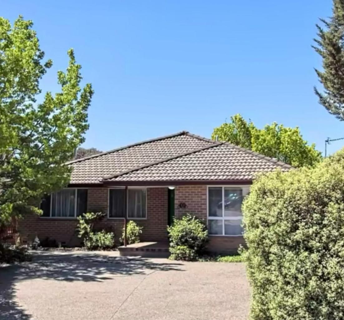 A Brick House with A Tiled Roof Is Surrounded by Trees and Bushes — CBR Maintenance In Curtin, ATC