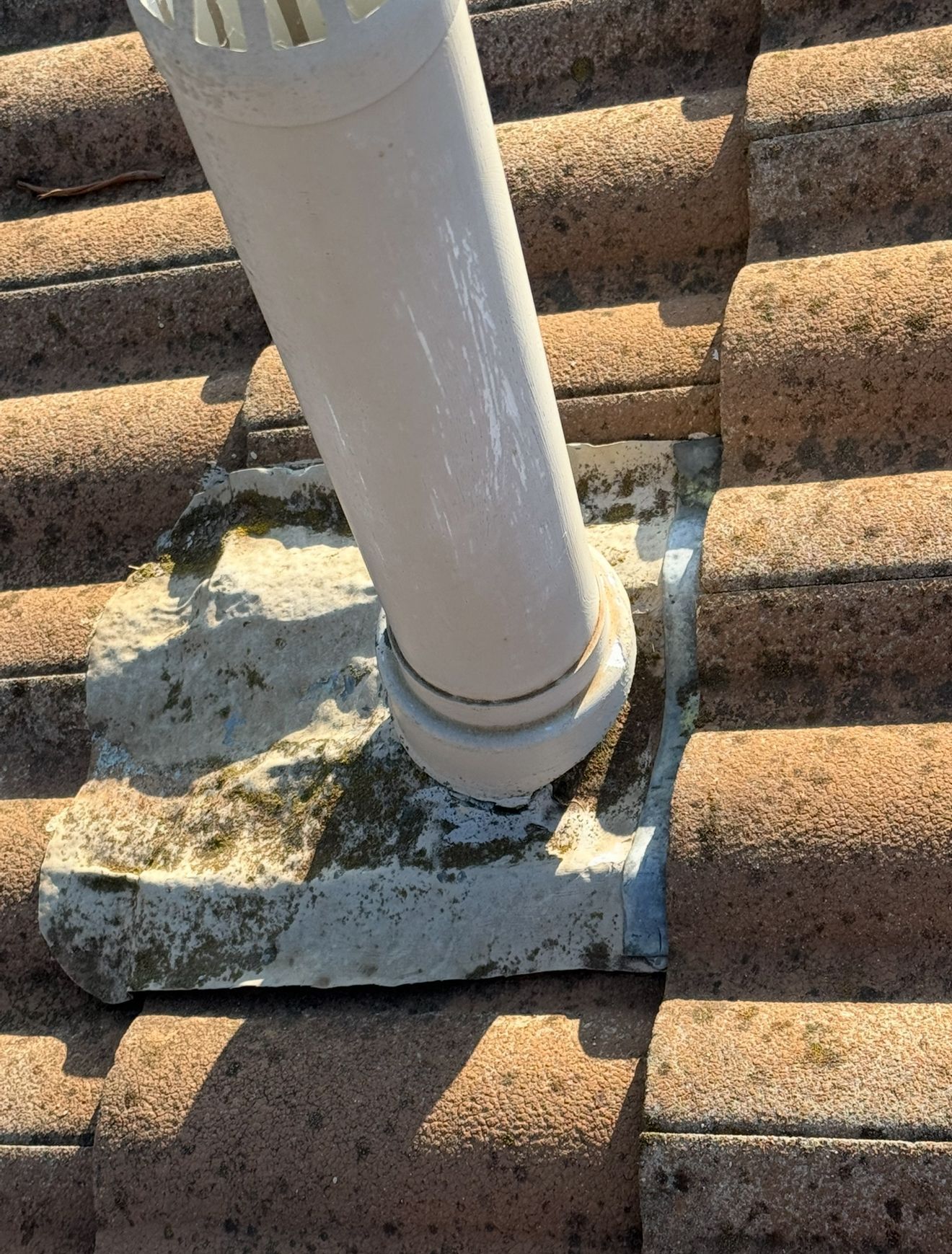 A white pipe is sitting on top of a tiled roof — CBR Maintenance In Tuggeranong, ATC