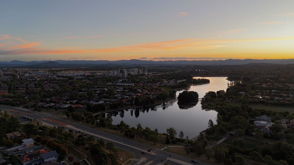An Aerial View of a Lake Surrounded by Trees and a City at Sunset — CBR Maintenance In Gungahlin, ATC