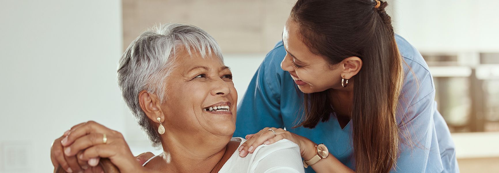 An elderly woman and a young girl are dancing together and smiling.