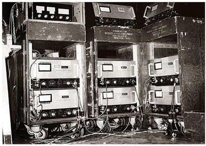Vintage electronic equipment on rolling racks; meters and controls visible.