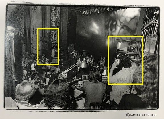 Black and white photo of a band playing on stage. A crowd watches. Highlighted figures: singer with mic, booth.