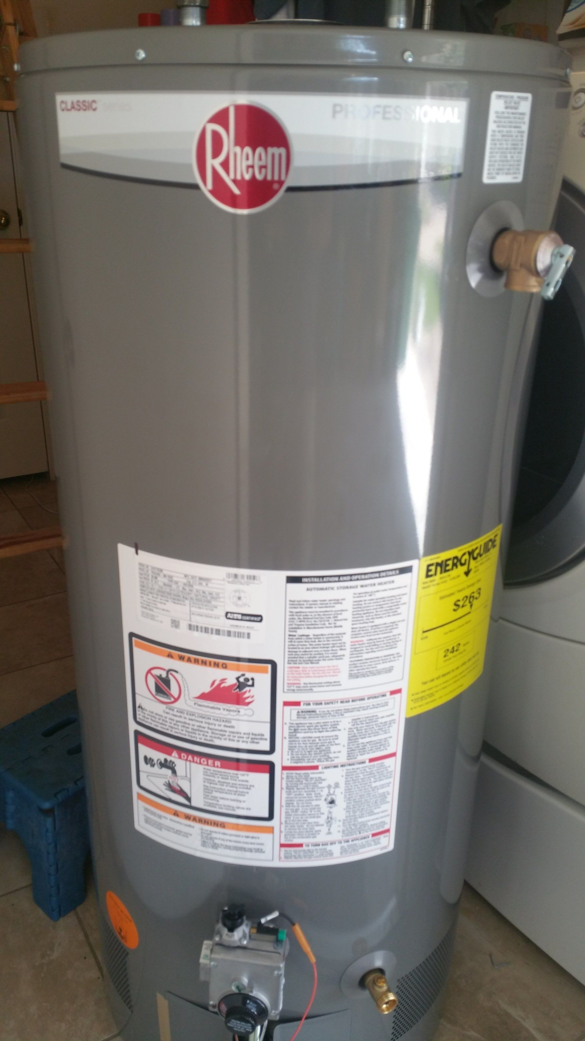 Rheem ProGas water heater, tall cylindrical gray tank with labels and a gas control valve.
