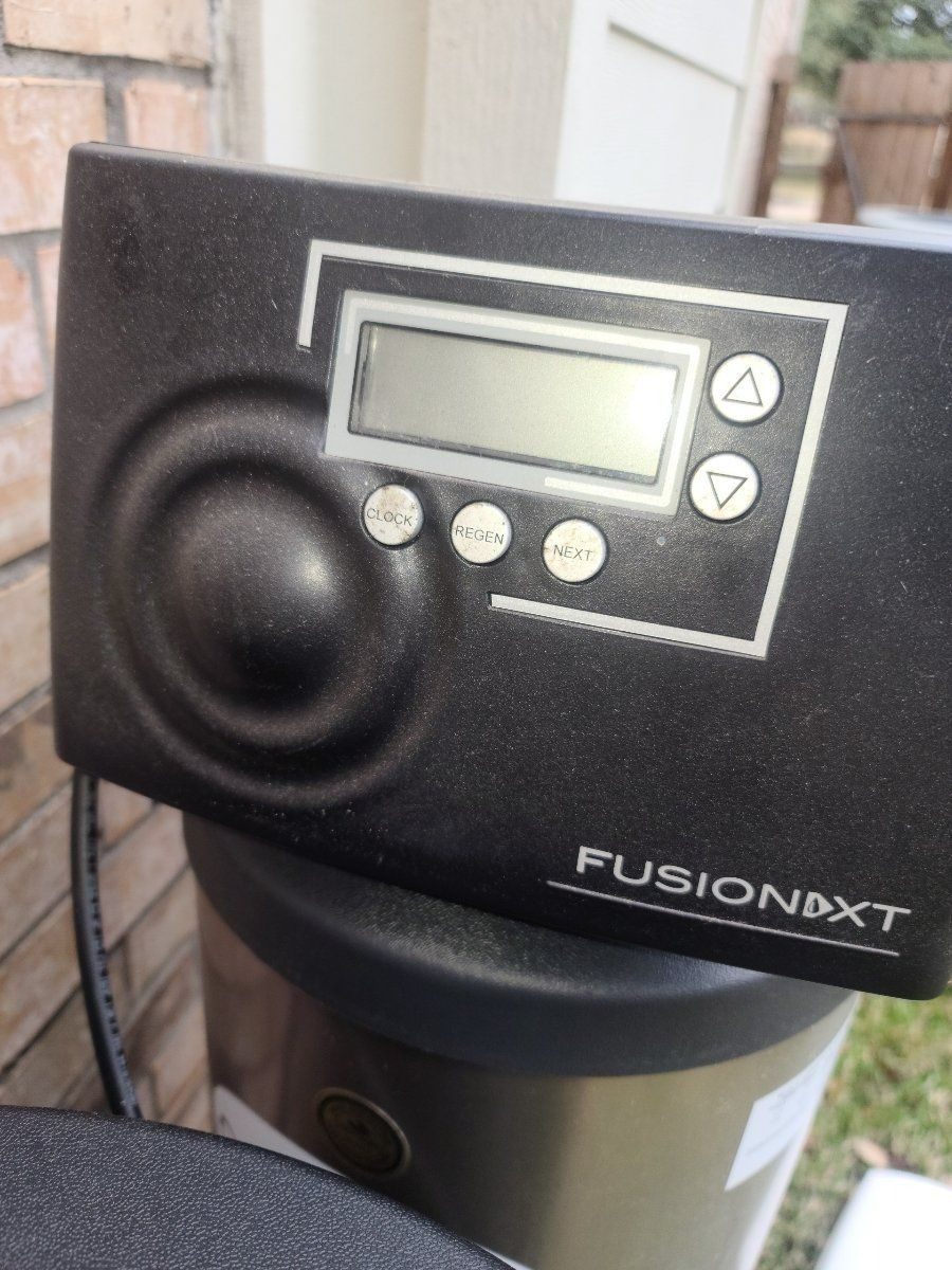 Black Fusion NXT water softener control panel with display and buttons.