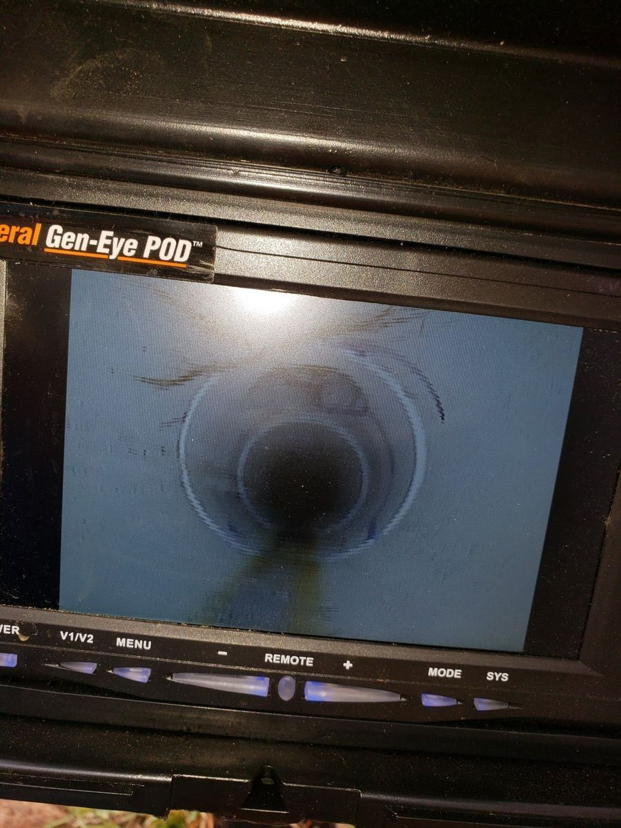 Screen shows a view down a gray pipe, possibly a drain. Some discoloration is visible.
