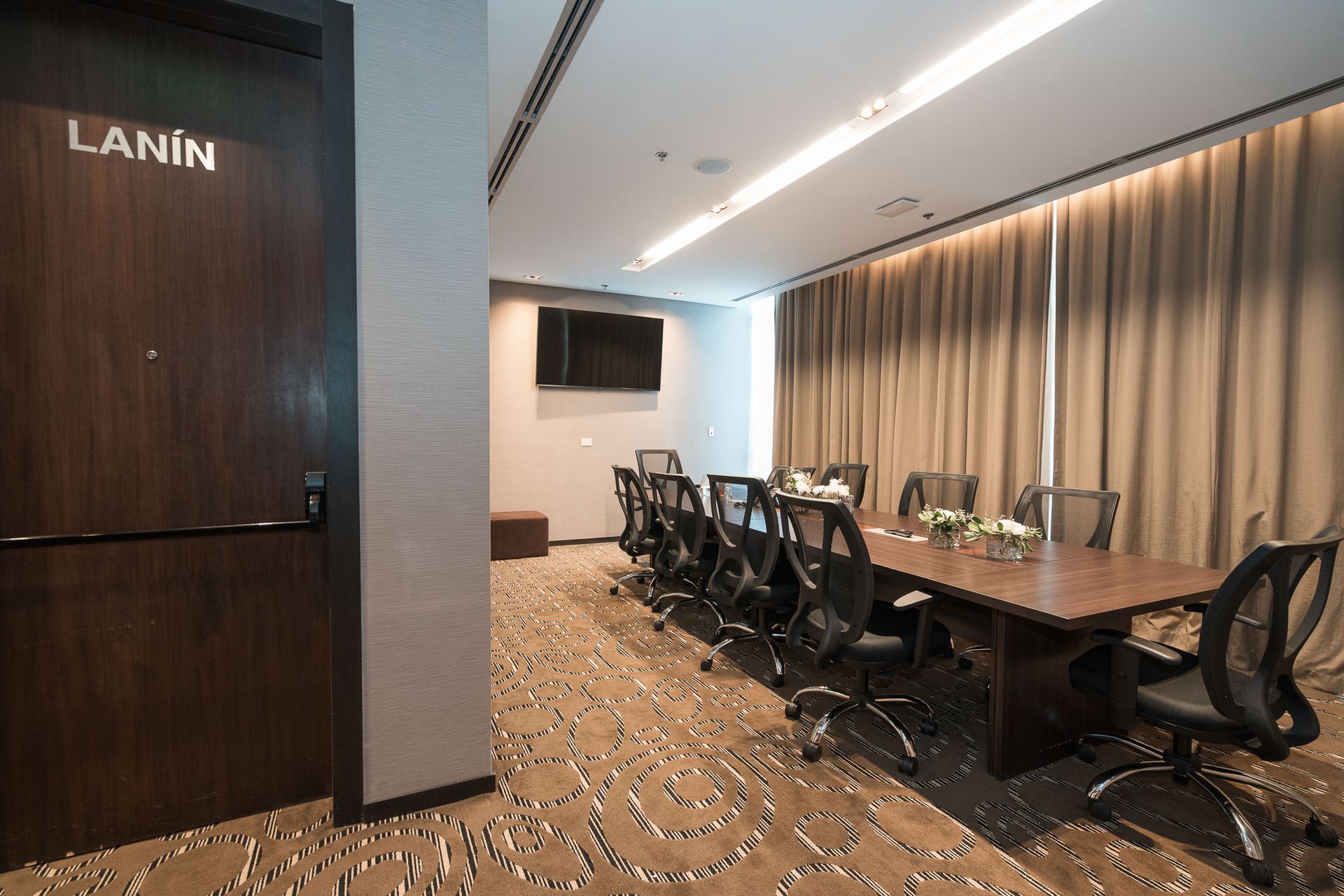 Una sala de conferencias con una mesa larga y sillas.