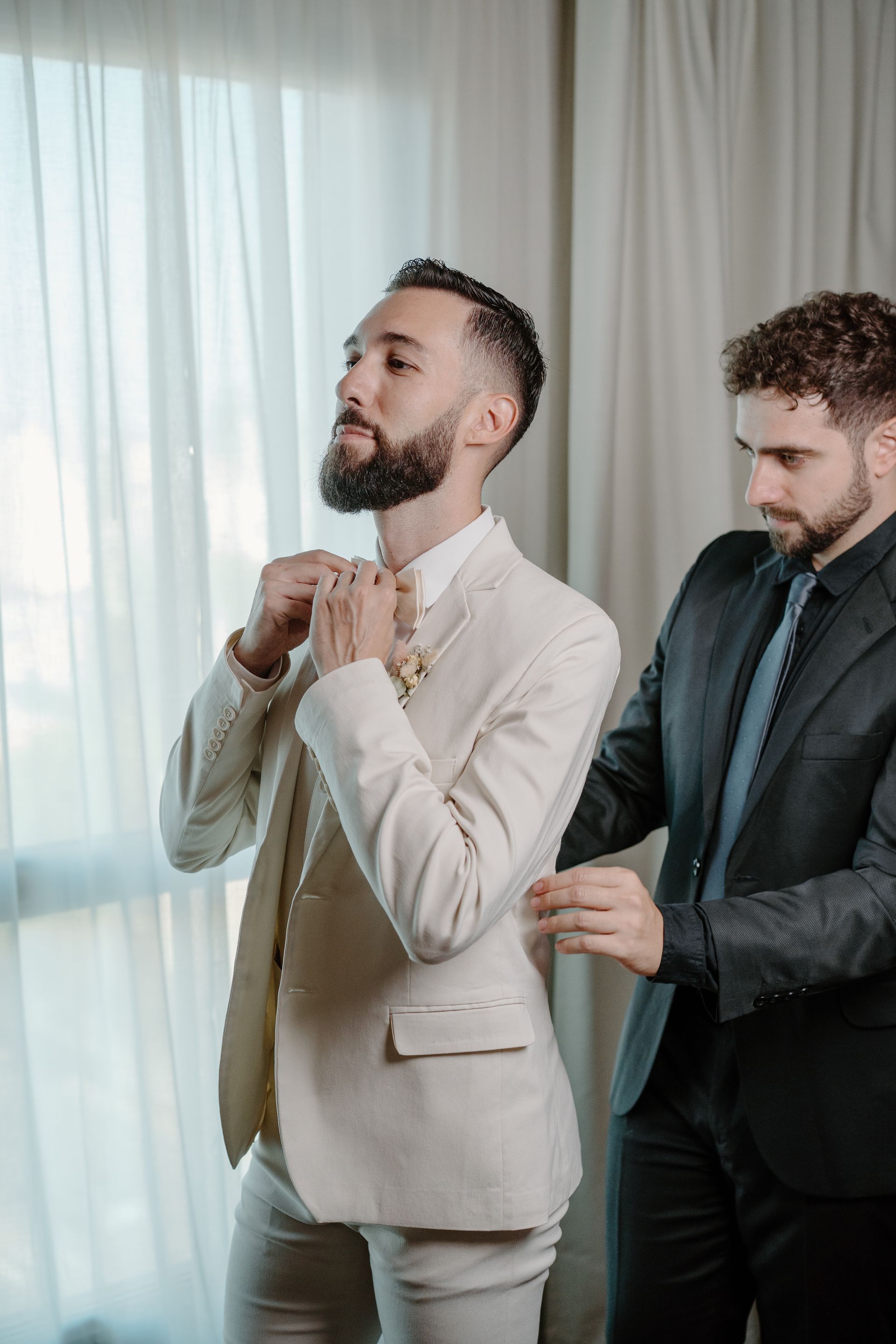 Un hombre vestido con una camisa blanca y gemelos se ata la corbata.