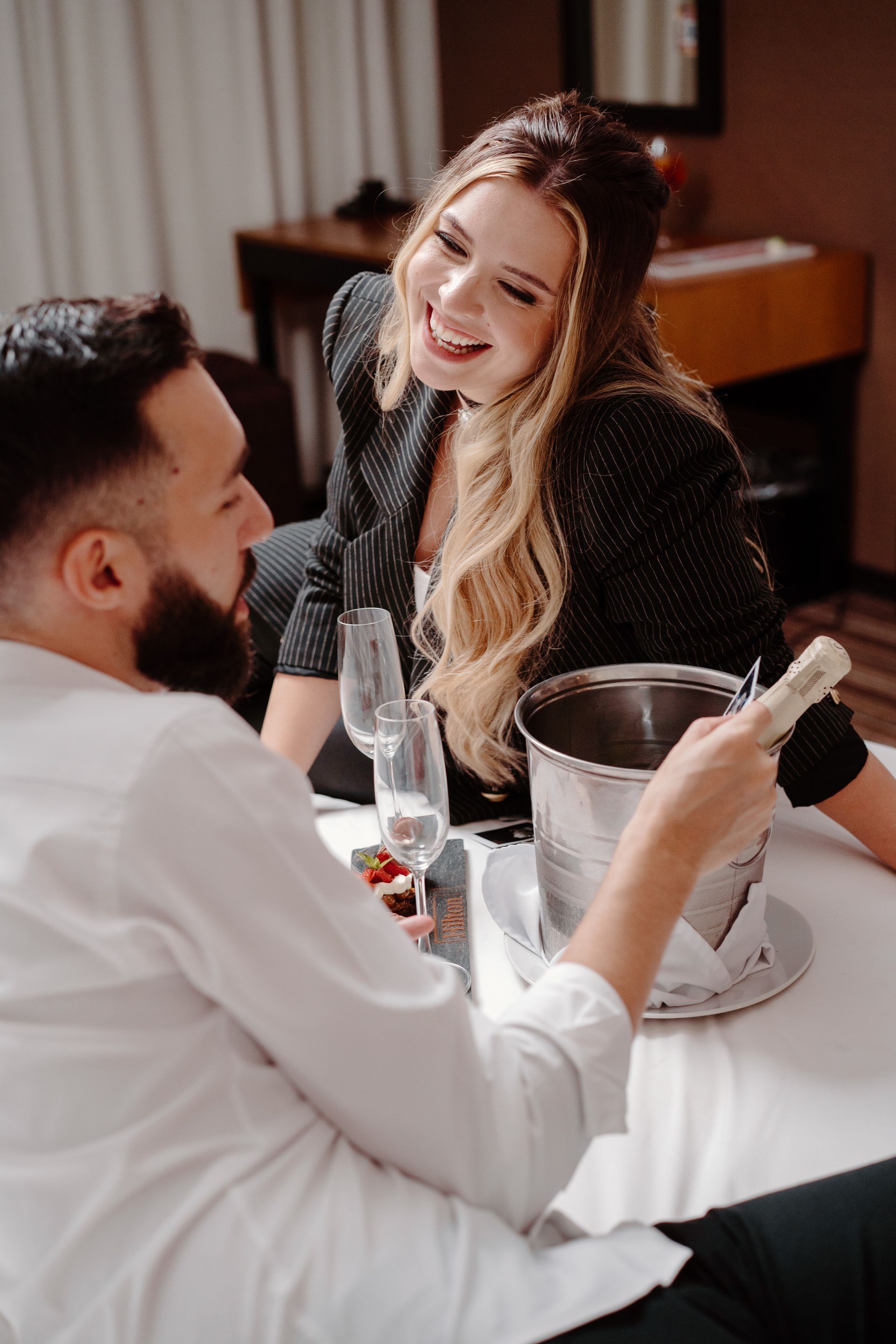 Un plato blanco rematado con un postre y una copa de vino.