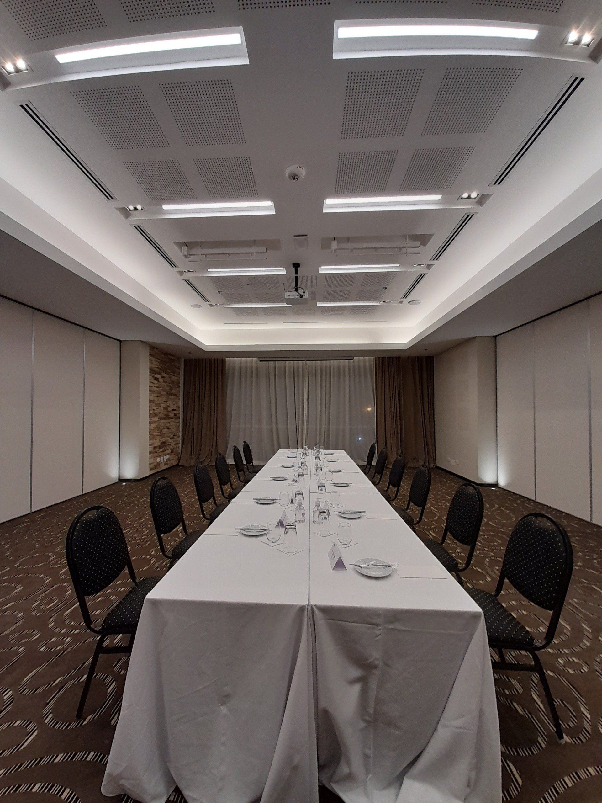 En el centro de la habitación hay una mesa larga con sillas.