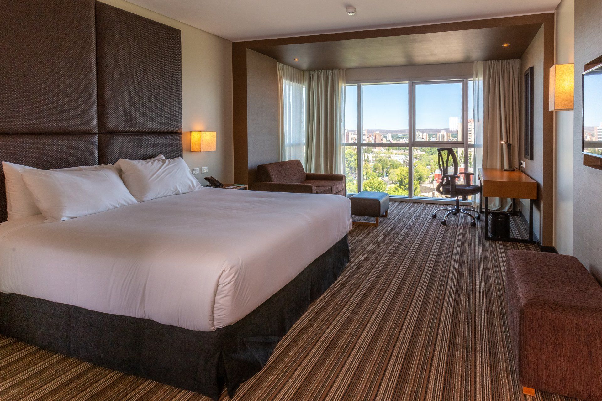 Una habitación de hotel con una cama grande y una ventana grande.