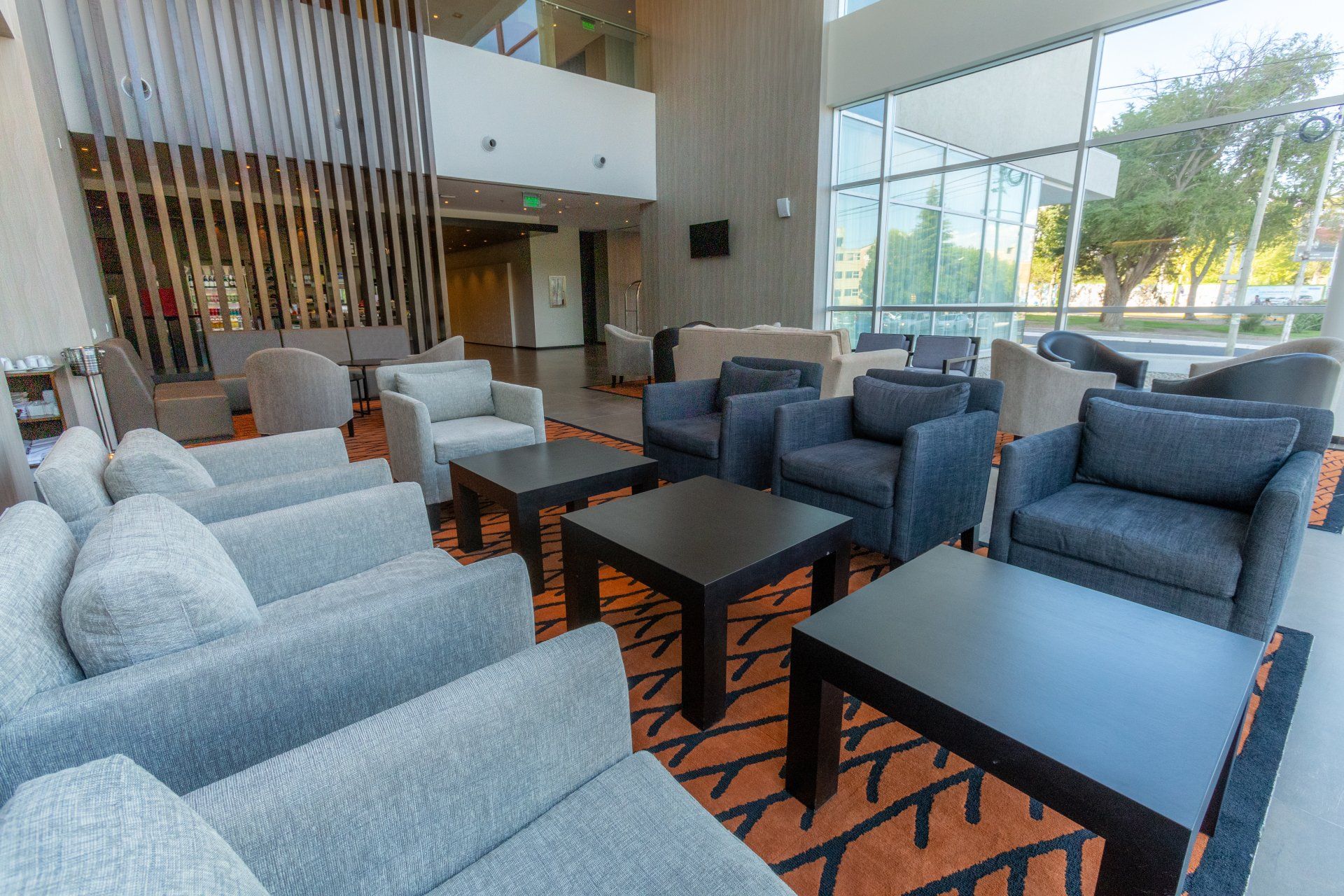 Hay muchas sillas y mesas en el vestíbulo de un hotel.