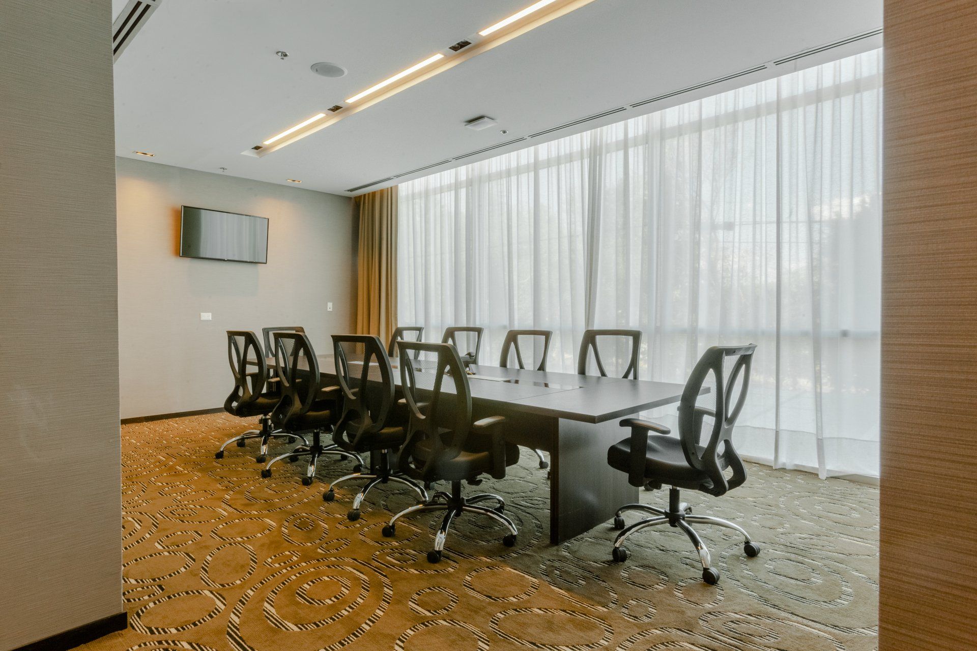 Una sala de conferencias con una mesa larga y sillas.