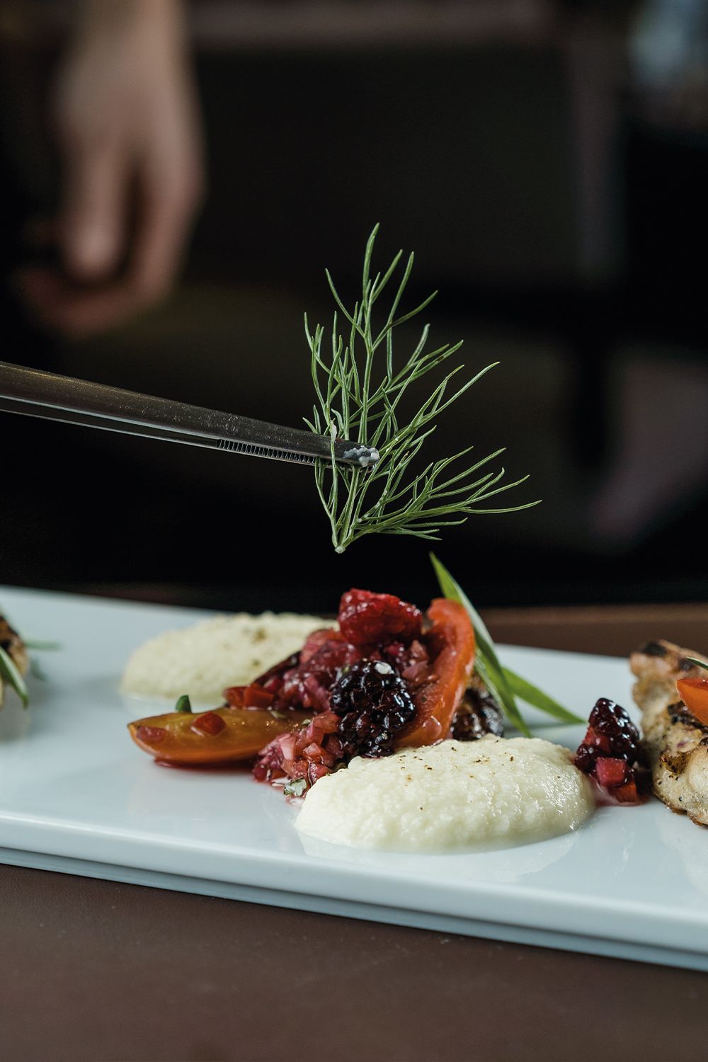 Un plato de comida con una ramita de romero encima.