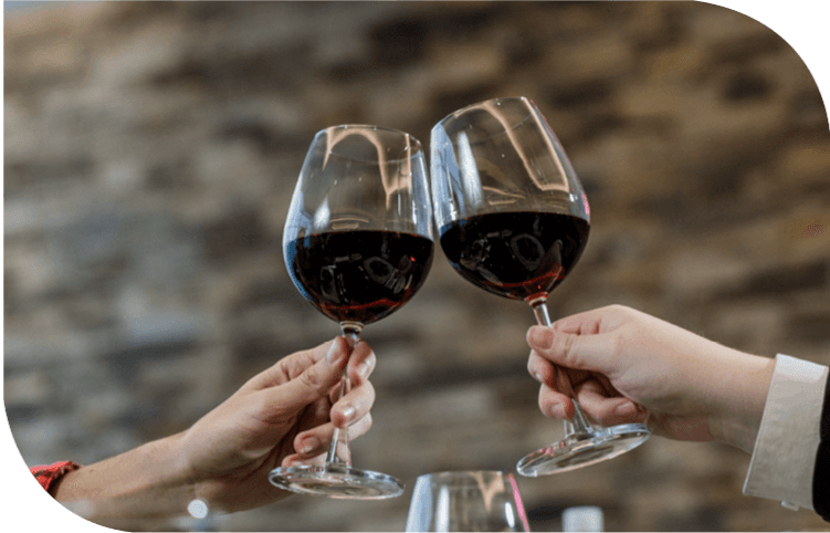 Dos personas brindan con copas de vino en un restaurante.