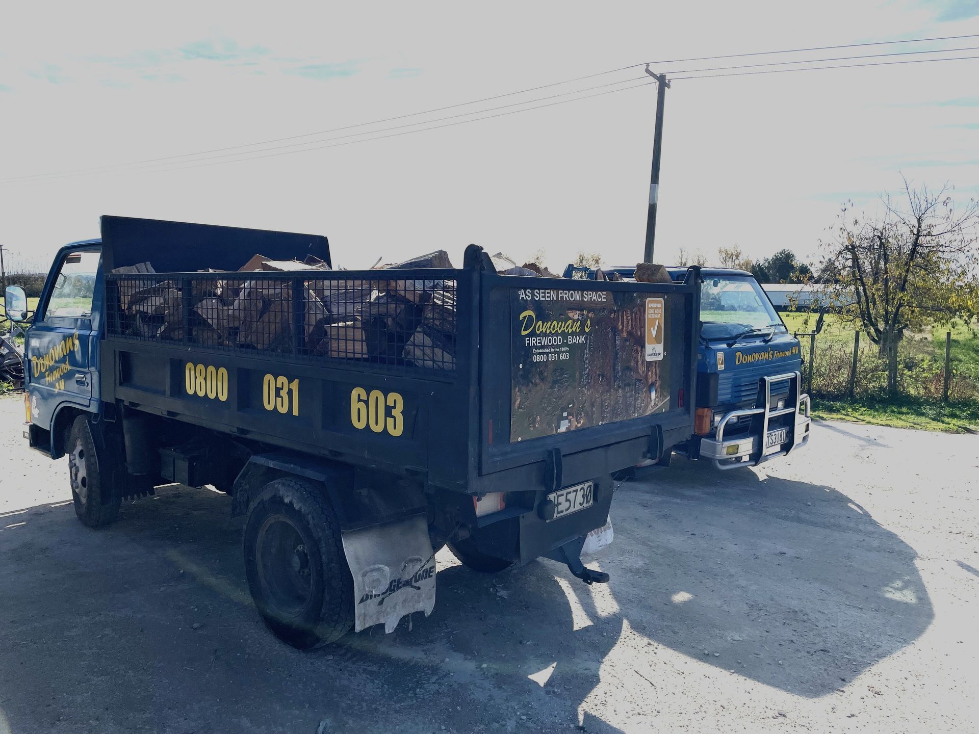 Two dump trucks are parked next to each other in a parking lot.