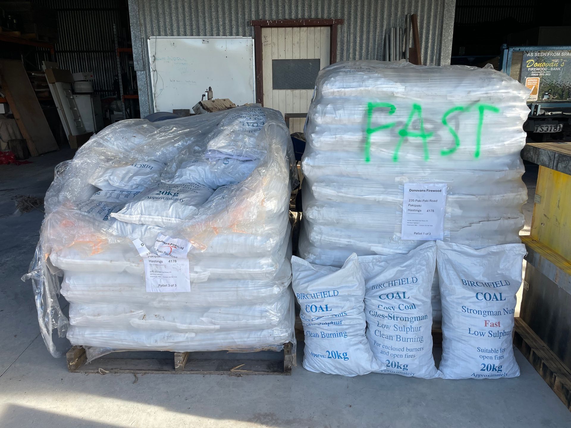 A bunch of bags are stacked on top of each other in front of a building.