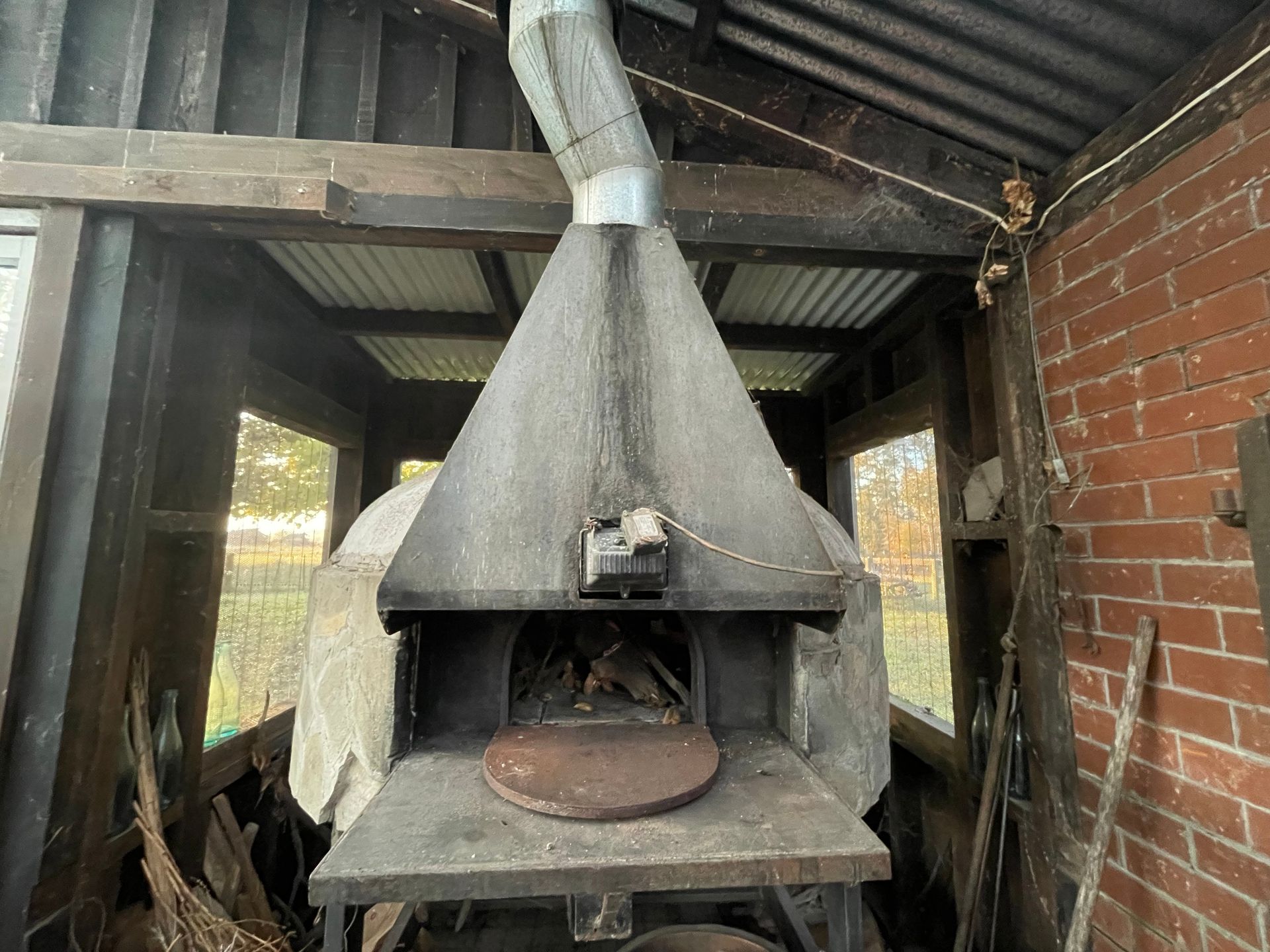 A large oven is sitting inside of a brick building.