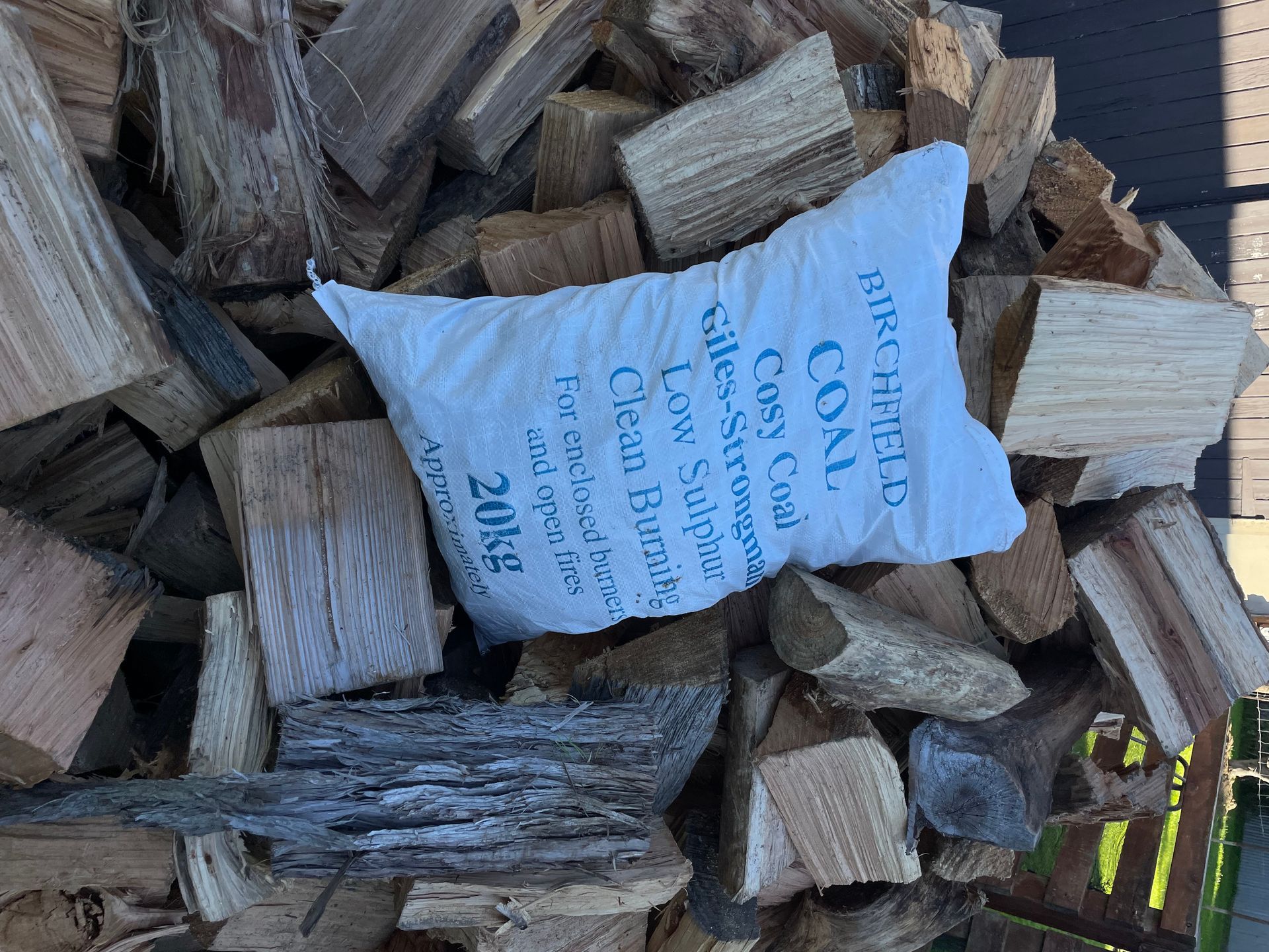 A bag of wood is sitting on top of a pile of wood.
