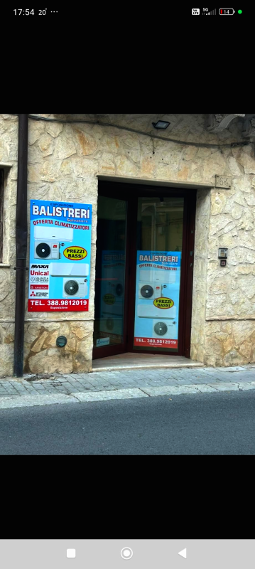 Vetrina con due insegne, una su ciascun lato dell'ingresso, che pubblicizzano servizi, probabilmente correlati alla manutenzione delle auto.