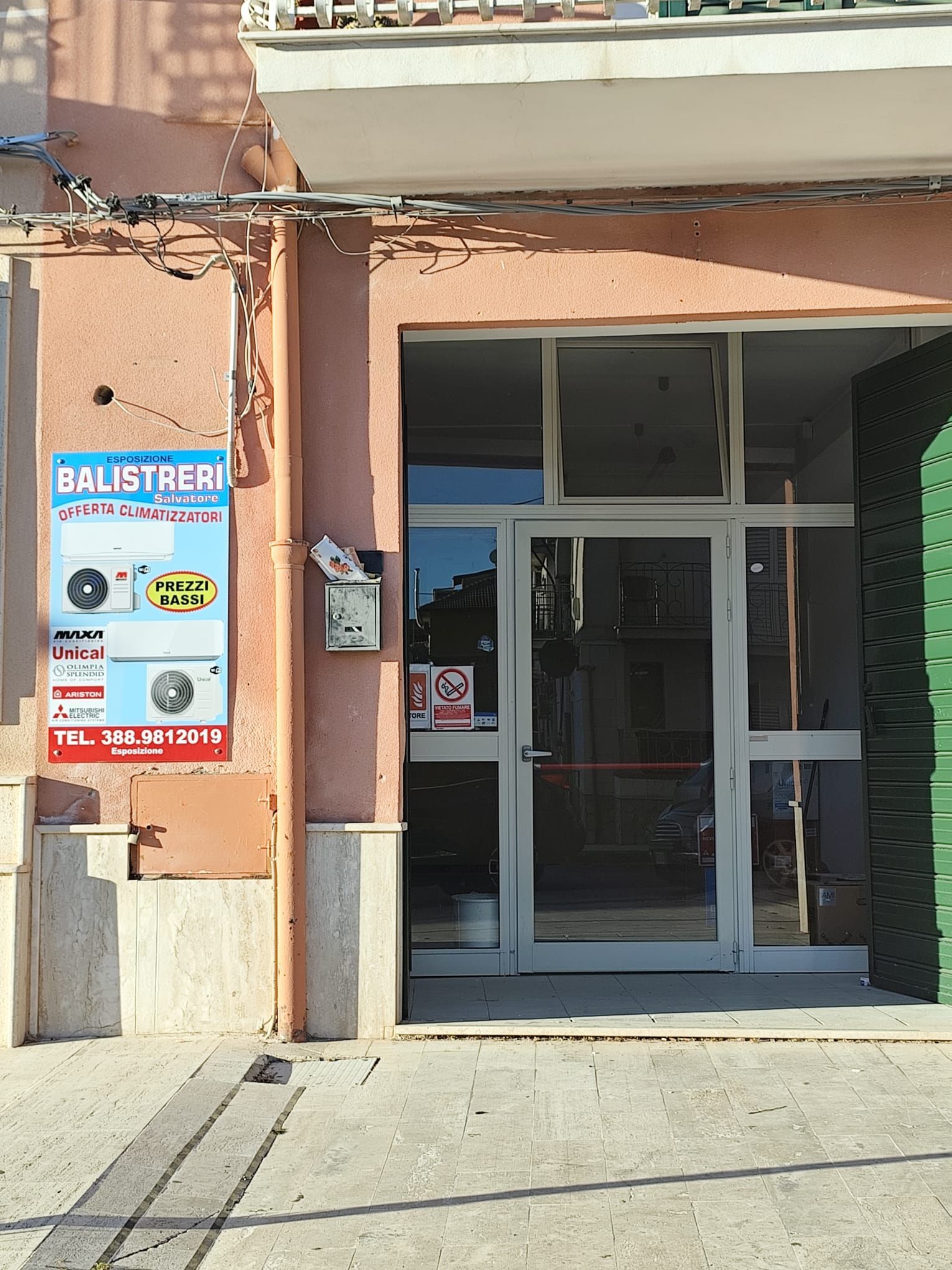 Vetrina con due insegne, una su ciascun lato dell'ingresso, che pubblicizzano servizi, probabilmente correlati alla manutenzione delle auto.