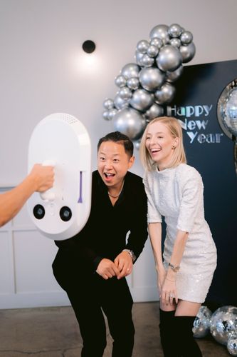 wo women laughing and posing at an iPad-powered EverGlow Booths photo booth in Boston, MA with vibrant purple lighting
