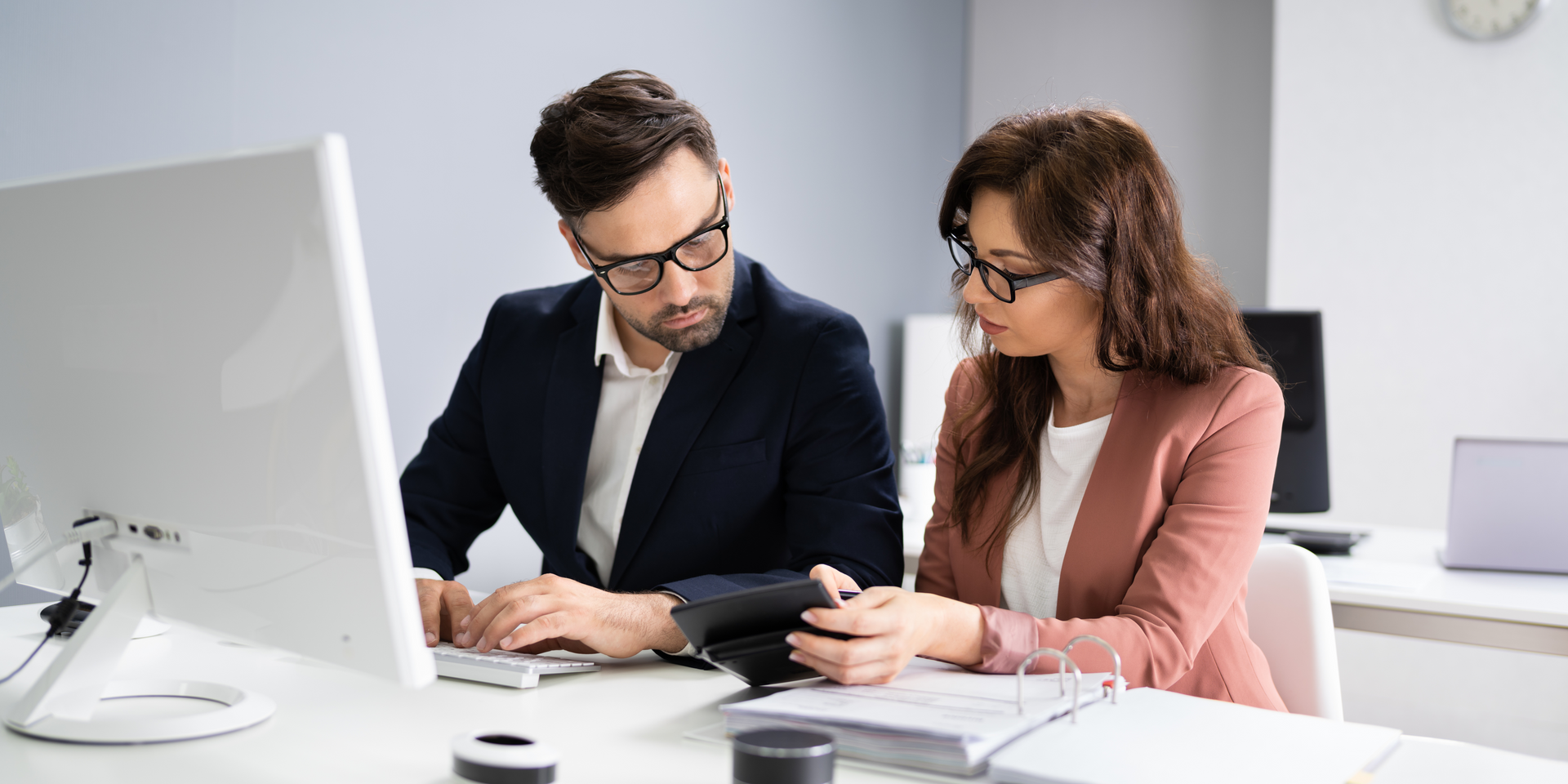 un homme et une femme regardent un écran d' ordinateur